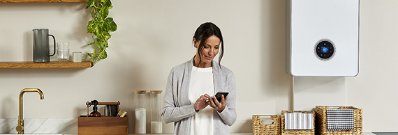 Woman in kitchen on her phone in front of new Worcester Bosch boiler